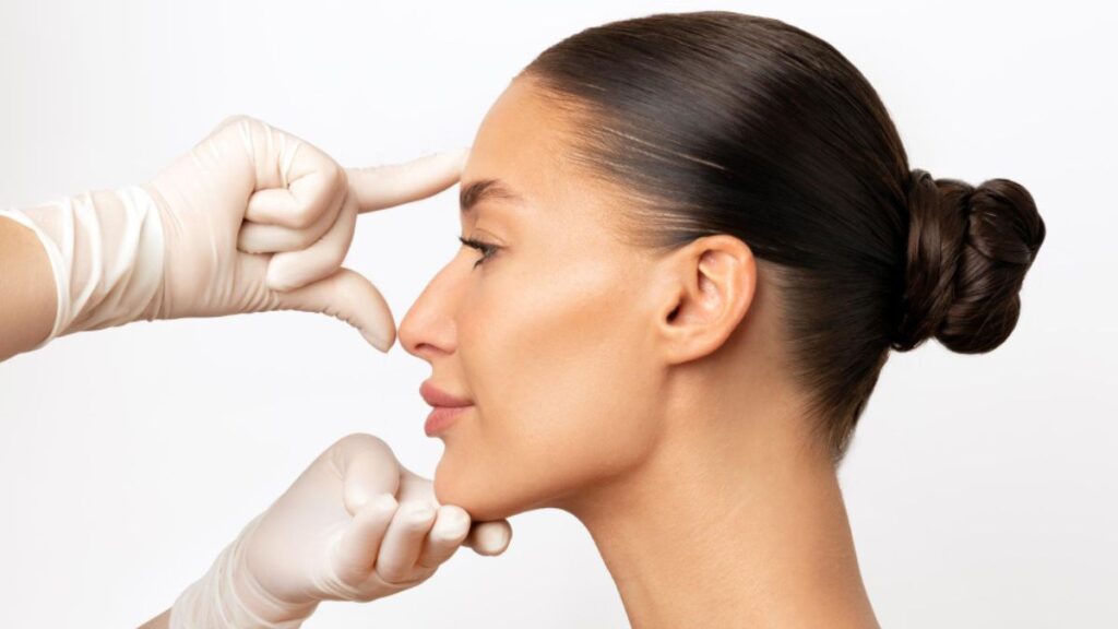 Cirurgião plástico avaliando rinoplastia aberta da cliente.