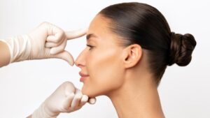 Cirurgião plástico avaliando rinoplastia aberta da cliente.